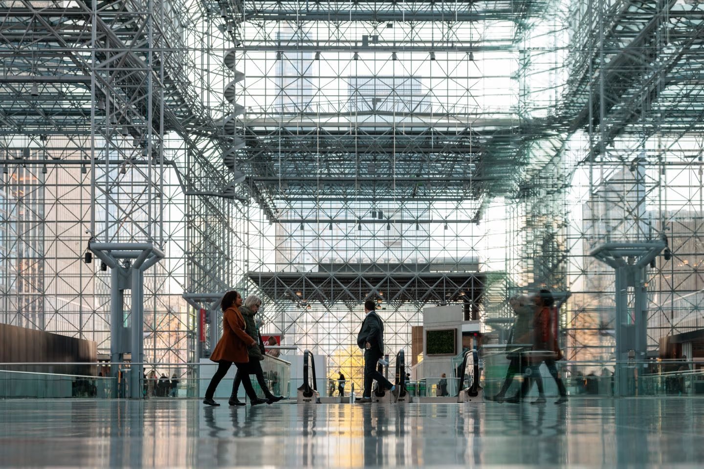 Attendees walking through the glass-roofed atrium of a convention centre