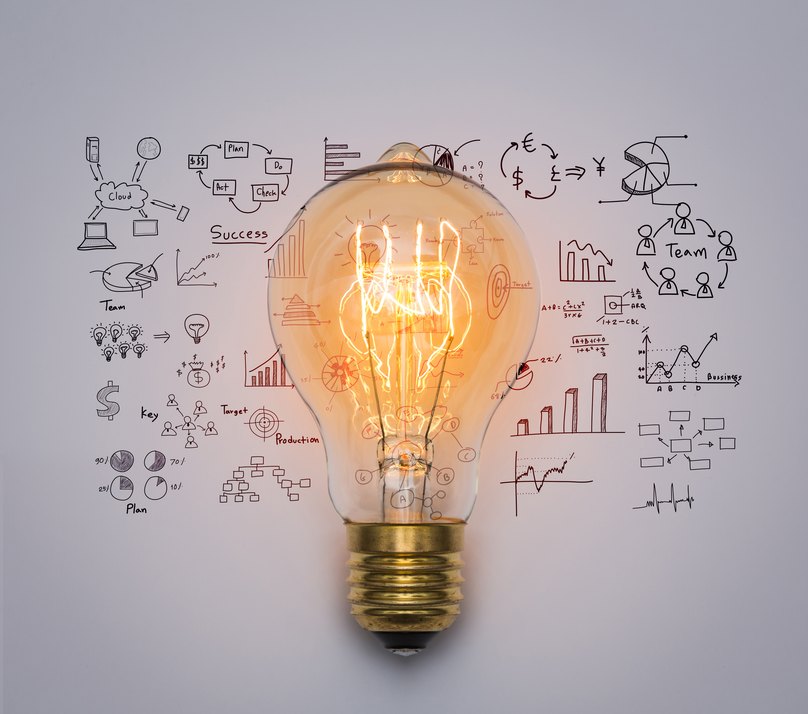A lit filament bulb surrounded by hand-drawn charts and diagrams